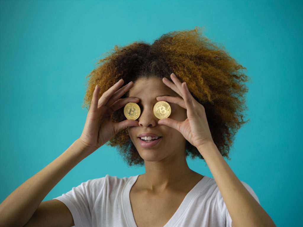 Woman holding two Bitcoins